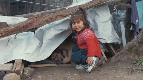 Süßes-Kleines-Mädchen-Sitzt-Mit-Ihrem-Hund-In-Einem-Flüchtlingslager-In-Griechenland