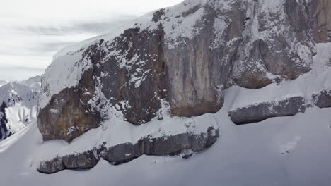Aerial-drone-shot-on-montain-rock-in-the-alps,-Austria,-Kleinwalsertal,-skiing-area,-snowy-mountains