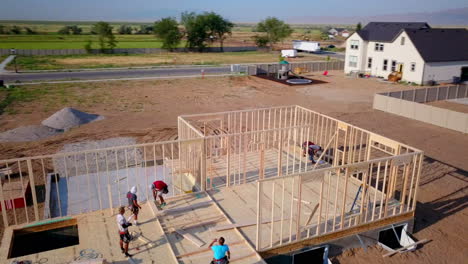 A-drone-shot-of-framers-putting-up-walls-on-a-new-home-in-the-process-of-being-built