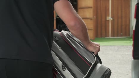 Caucasian-man-taking-out-golf-bags-with-club-from-van