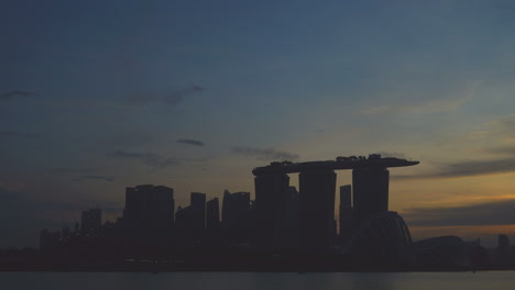 Singapur---Ca.-Schöner-Zeitraffer-Mit-Dolly-Zoom-Von-Tag-Zu-Nacht-Der-Skyline-Von-Singapur-Mit-Sich-Bewegenden-Wolken-Im-Hintergrund