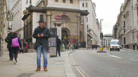 Hombre-Asiático-Decepcionado-Leyendo-Un-Mensaje-De-Texto-En-El-Distrito-Financiero-De-Londres