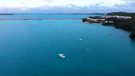 Aerial-view-of-long-car-bridge-over-clear-turquoise-water-on-tropical-island