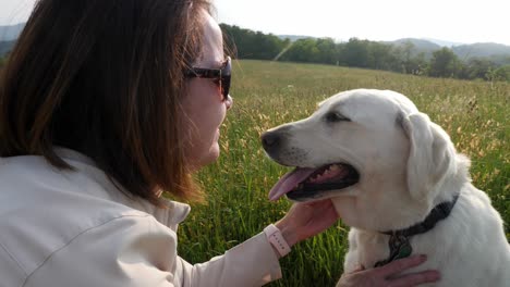 Mujer-Juega-Con-Un-Perro-Labrador-Blanco-Con-Fondo-De-Montaña