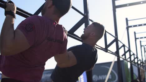 Hombres-Caucásicos-Atléticos-Fuertes-Haciendo-Pull-Ups-En-Una-Competencia-De-Ajuste-Cruzado,-Una-Parte-Superior-Del-Cuerpo-Popular-Y