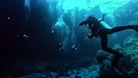 Divers-penetrating-the-bottom-of-the-sea-seen-from-the-back