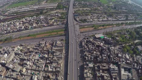Aerial-view-over-the-Traffic-passes-at-junction-with-canal,-bridge-highway