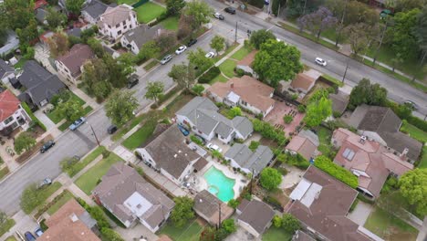 Aerial-Drone-footage-of-Neighborhood-in-Suburbia-Pasadena,-California-USA-Residential-of-Houses-Roads-with-cars,-approaching-train-tracks