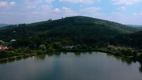 Flying-towards-a-hill-at-a-lakeshore---Aerial-footage-of-the-hill-at-the-lakeshore-of-Bánk,-Nógrád-County,-Hungary