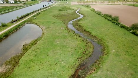 Drone-footage-of-the-river,-pathway,-and-bridge-near-the-canal-in-Holland