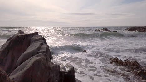 Waves-Breaking-Against-a-Rocky-Cove-on-a-Summer’s-Evening-in-Slow-Motion