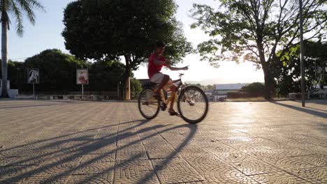 Children-on-bikes-playing-in-a-patio-at-sunset