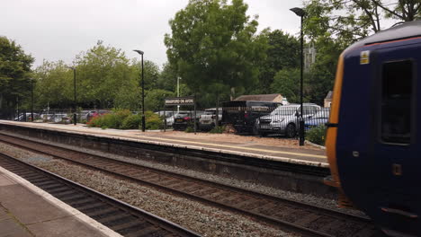 Der-Erste-Great-Western-Zug-Verlässt-Bradford-Am-Bahnhof-Avon-In-Wiltshire-Und-Enthüllt-Altmodische-Beschilderungen-Auf-Einem-Anderen-Bahnsteig