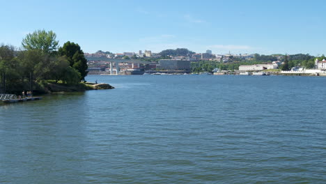 Sobrevuelo-Del-Río-Douro,-Mirando-El-Puente-Freixo-En-Oporto,-Con-Una-Persona-Pescando