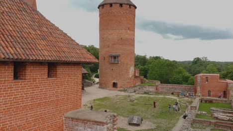 Toma-Aérea-Bajando-Enfocada-En-La-Torre-Principal-Del-Castillo-De-Turaida-En-Letonia