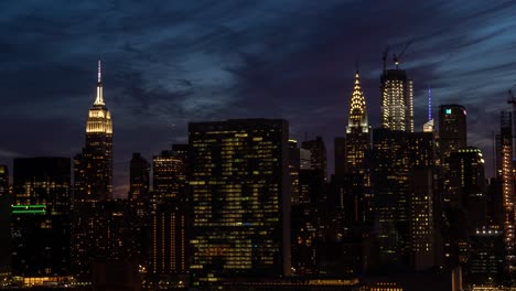 Time-Lapse-of-beautiful-purple-sunset-at-Manhattan,-New-York-City,-with-Empire-State-Building,-the-Chrysler-building,-and-the-UN-building-in-the-foreground-at-summer-2019