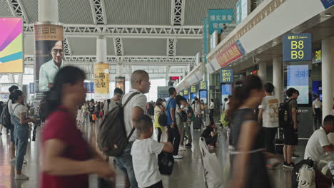 Zeitraffer-Der-Wartehalle-Des-Südbahnhofs-Des-Hochgeschwindigkeitszugs-Guangzhou,-Mit-Zahlreichen-Passagieren,-Die-Vorbeikommen-Und-Auf-Den-Sitzen-Sitzen,-Guangzhou,-China