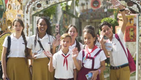 day-shot-close-up-of-children-at-Havana-Cuba-elementary-school-waving-smiling-and-saying-hallo-to-the-camera-,-beautiful-uniform-yellow-,-red-white-young-children-standing-slow-motion