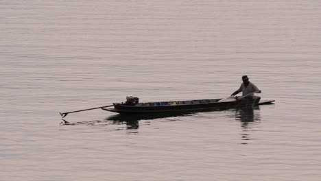 Pescador-Perfilando-Mientras-Lanza-Y-Saca-Su-Red-En-El-Río-Antes-Del-Anochecer,-En-Cámara-Lenta