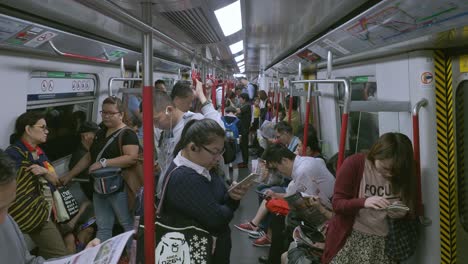 Viajeros-En-Un-Tren-De-Transporte-Público-Lleno-De-Gente-O-En-Un-Tren-Mrt-En-La-Red-De-Transporte-Subterráneo-De-Hong-Kong