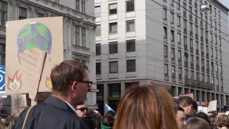 Protestors-standing,-holding-up-signs-during-fridays-for-future-climate-change-protests-in-Vienna,-Austria