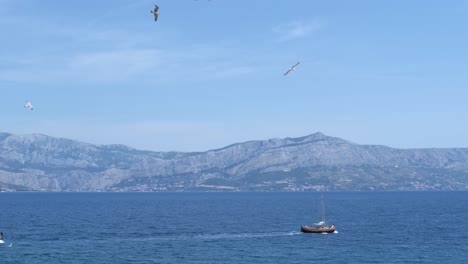 Los-Barcos-Cruzan-El-Medio-Del-Mar-Con-Pájaros-Voladores-En-El-Aire