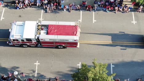 Static-aerial-as-parade-firetruck-and-Navy-Club-USA-Ship-float-pass-by-crowds-on-street