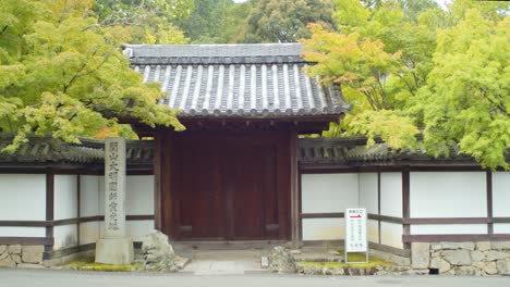 Entrada-De-Puerta-De-Madera-Al-Lado-De-Una-Carretera-En-Kyoto,-Japón-Iluminación-Suave-Cámara-Lenta-4k