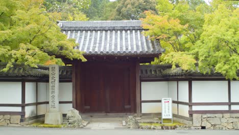 Wooden-gate-entrance-on-the-side-of-a-road-in-Kyoto,-Japan-soft-lighting-slow-motion-4K