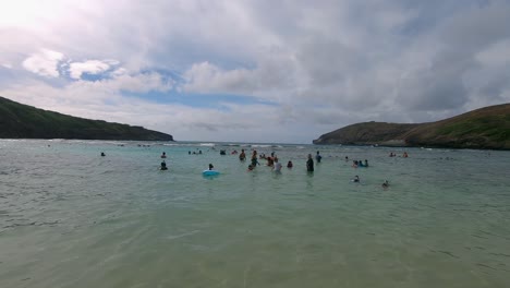 Families-playing-in-the-water-at-the-beautiful-tropical-beach-of-Hanauma-Bay-State-Park-and-Nature-Preserve-on-Oahu-Island-in-Hawaii-on-a-cloudy-day