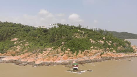 Zoom-out-aerial-shot-revealing-Coloane-coastline-and-traditional-Chinese-pavilion