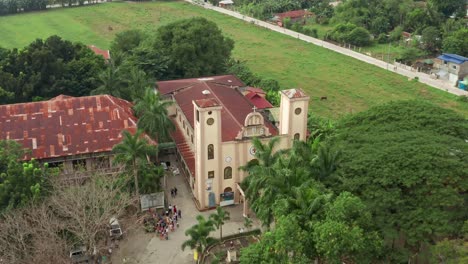 Luftaufnahme-Einer-Katholischen-Kirche-Auf-Den-Philippinen-Mit-Menschenmenge-In-Der-Nähe-Des-Eingangs-In-4K