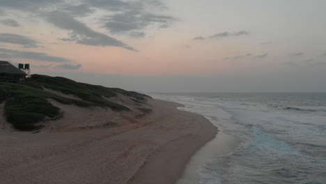 Aerial-view-of-lodge-by-sand-dunes-and-open-ocean-in-Mozambique