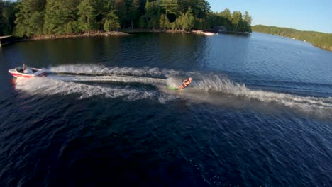 Slow-Motion---Caucasian-Male-Water-Skier-Jumps-Boat-Wake-on-Blue-Lake-in-Summer-Sunset-Light,-FPV-Drone-Aerial-Orbit-Track