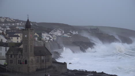 Storm-Ciara-causes-huge-waves-to-crash-into-the-cliffs-of-the-Cornish-coastline-behind-the-famous-Porthleven-town-hall-at-the-end-of-the-historic-harbour-as-a-car-drives-past