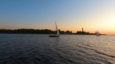 Sailboat-sailing-in-the-sea-to-watch-the-sunset