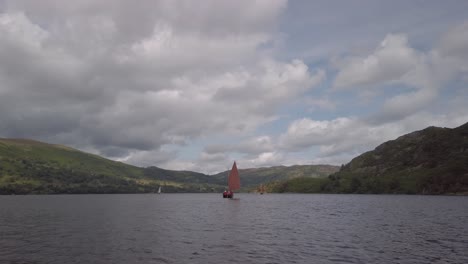Children-under-the-instruction-of-an-adult,-sailing-a-beautiful-traditional-sailing-boat-on-Ullswater-Lake-near-the-village-of-Glenridding