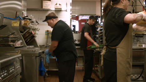 Toma-Estabilizada-De-Los-Empleados-De-Mcdonald&#39;s-Trabajando-En-La-Parrilla-Y-El-área-De-Preparación-En-La-Parte-Trasera-De-La-Cocina-Del-Restaurante