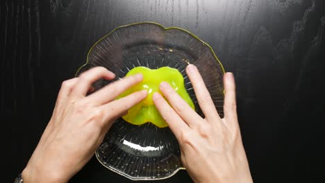 Playing-with-a-yellow-slime-bobble-in-a-glass-bowl