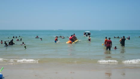 A-group-of-men-are-having-fun-riding-a-banana-boat-off-the-coast-of-Port-Dickson,-Malaysia