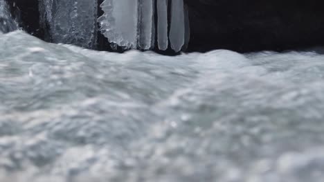 Wasserfall-In-Der-Wintersaison,-Der-Eis-Und-Blasen-In-Blau--Und-Kalttönen-Bildet