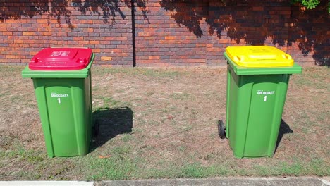 Red-and-yellow-Gold-Coast-Bins,-to-help-segregate-rubbish-being-thrown-and-avoid-pollution---Wide-shot