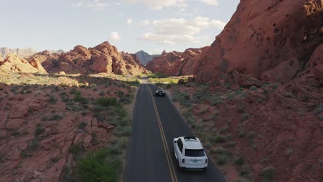 Ferrari-and-Rolls-Royce-driving-through-canyons-in-the-Valley-of-Fire,-Nevada,-USA