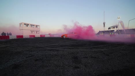 Der-Orangefarbene-Nissan-Skyline-R34-Erleidet-Einen-Massiven-Burnout-Mit-Rosa-Rauch-Aus-Den-Reifen