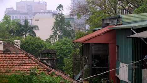 Home-and-building-rooftops-among-trees-in-Hanoi-Vietnam-during-an-overcast-humid-day,-Locked-establishing-shot