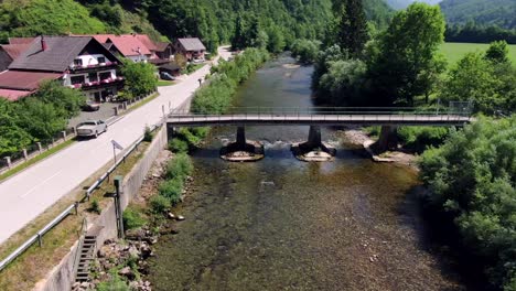 Volando-Sobre-Un-Río-Cerca-De-Un-Puente-En-Osilnica-En-Eslovenia,-Europa