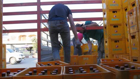 Lao-men-loading-gold-beer-crate-cargo-delivery-onto-back-of-truck