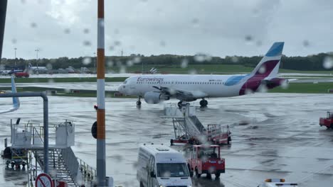 Aircraft-activity-on-the-airport-apron-through-a-window-covered-in-raindrops