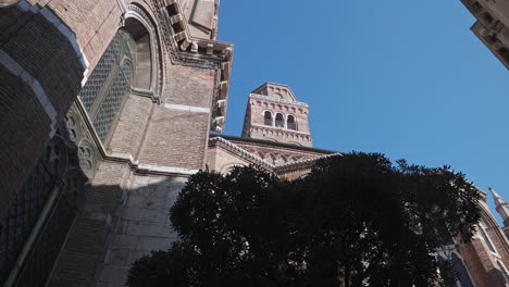 Baroque-bell-tower-of-a-Basilica-di-Santa-Maria-Gloriosa-dei-Frari,-antique-church-in-Venice,-northern-Italy,-Low-angle-shot