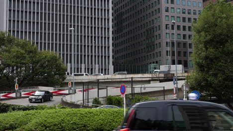 Slow-motion-shot-of-cars-coming-down-from-a-highway,-on-a-overcast,-autumn-day,-in-Tokyo,-Japan